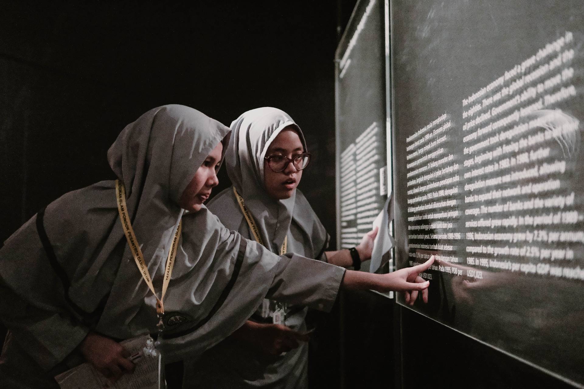 Siswi membaca informasi sejarah keuangan