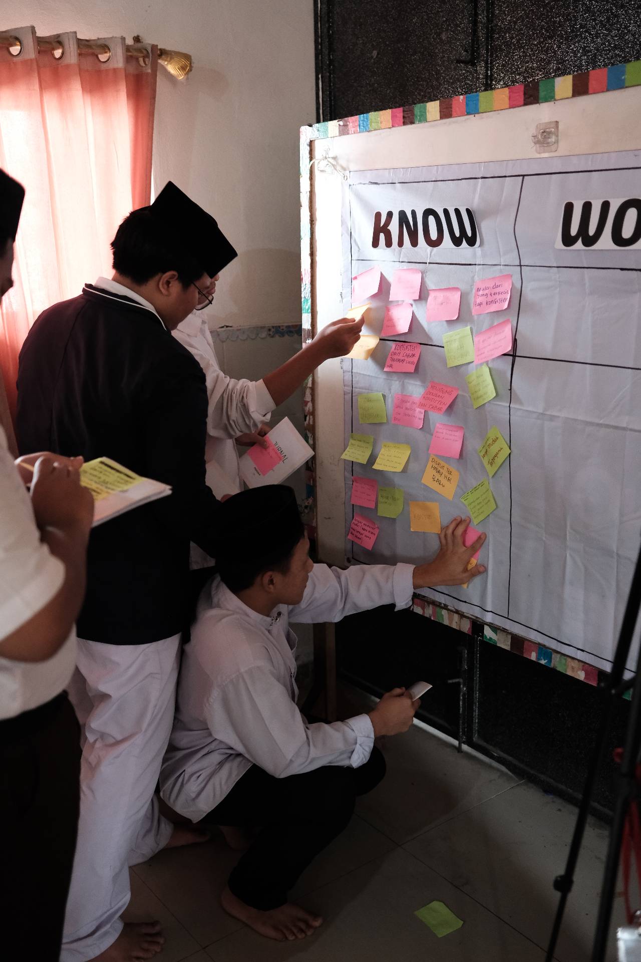 Santri menempelkan ide di papan KWL